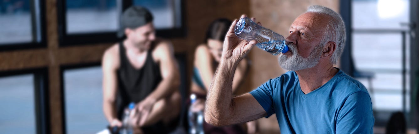 Man drinking water whilst exercising