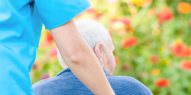 Nurse Pushing Male Patient in Wheelchair